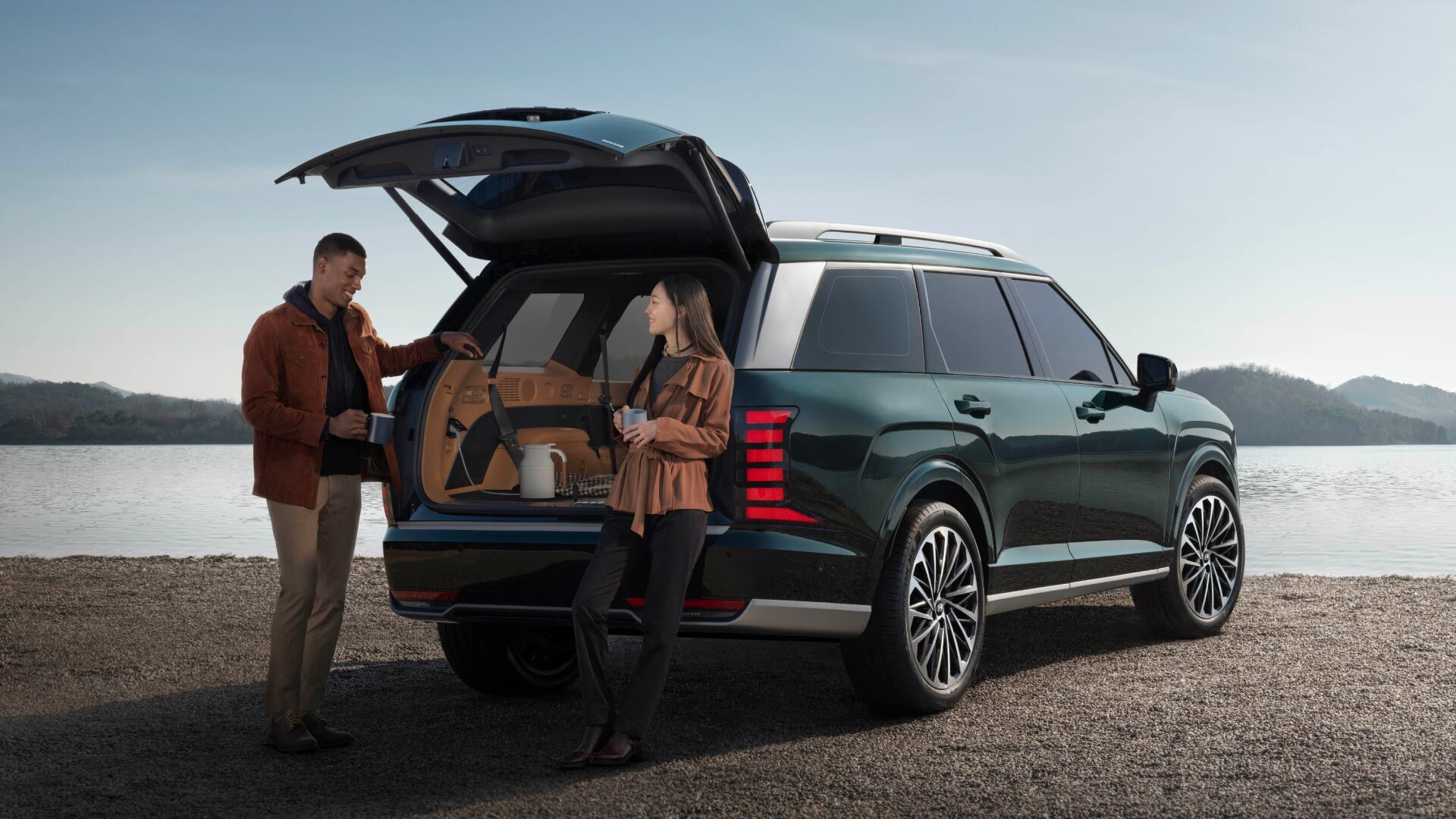 Side-front view of orange Grandi10 with lakeside view at night